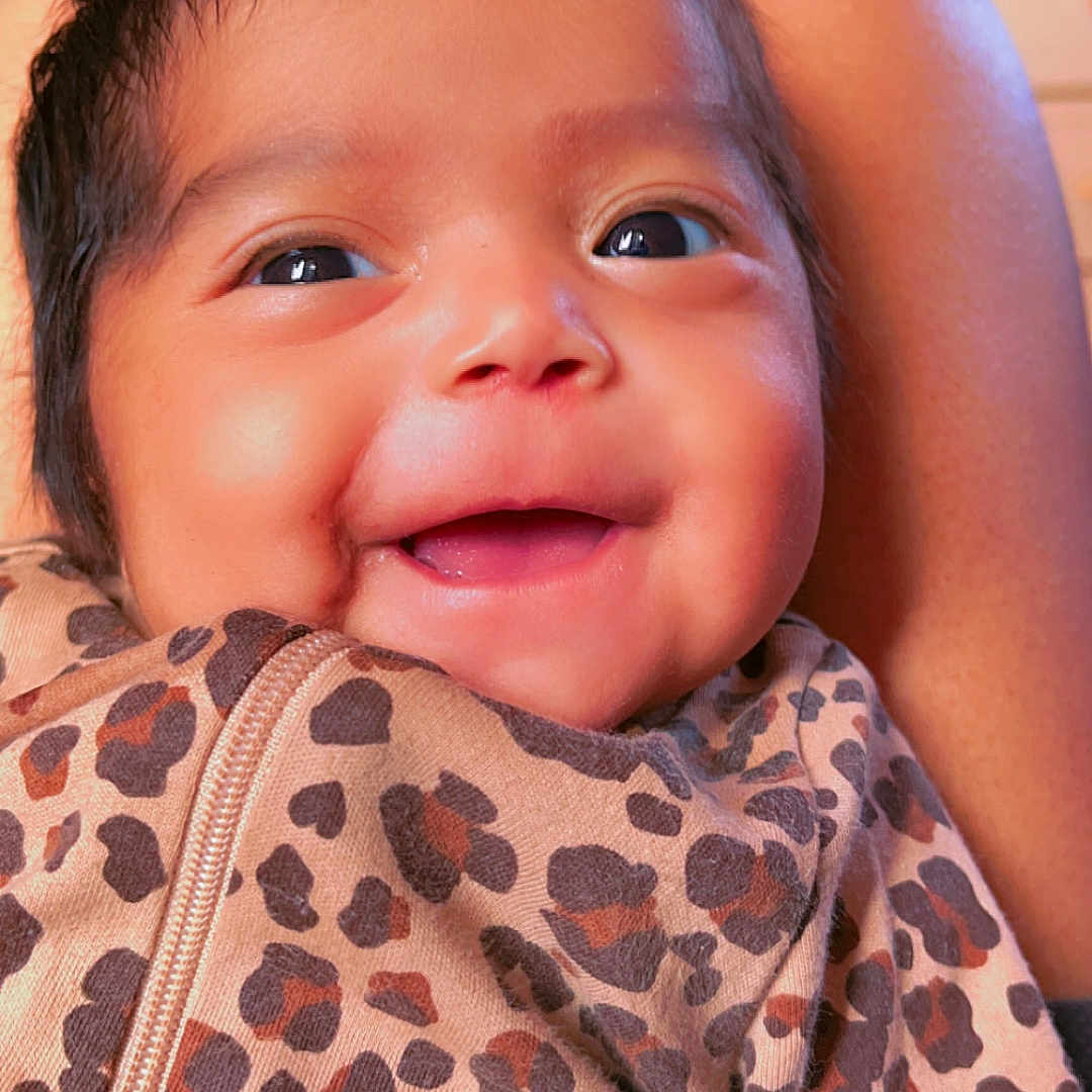 Sophia Tsosie is registered to the contest to win money with this photo: baby, child, closeup, clothing, cute, expression, eyes, face, happy, head, indoor, infant, joy, leopard_print, person, portrait, skin, smiling, warm, young