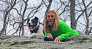 Luna joined the competition — help win amazing prizes! person, dog, rock, tree, bare_tree, outdoor, nature, tongue_out, green_shirt, happy_dog, playful, funny_face, pet, animal, landscape, daytime, casual, smile, leisure, friendship