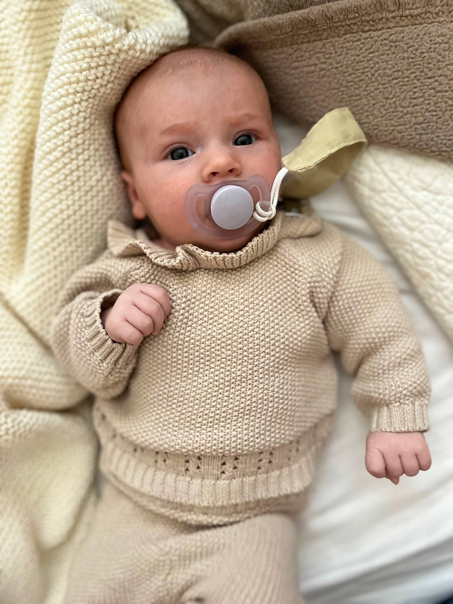 Katie is registered to the contest to win money with this photo: baby, baby_products, baby_safety, baby_sleeping, baby_toddler_clothing, cheek, child, collar, comfort, craft, fashion_accessory, linens, pattern, person, skin, sleeve, textile, toddler, wool, woolen