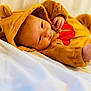 baby, infant, onesie, costume, bear_ears, fuzzy_clothing, soft_blanket, white_background, cute, child, portrait, laying_down, small_hands, sleepwear, warm_clothing, indoors, adorable, young_child, resting, cozy