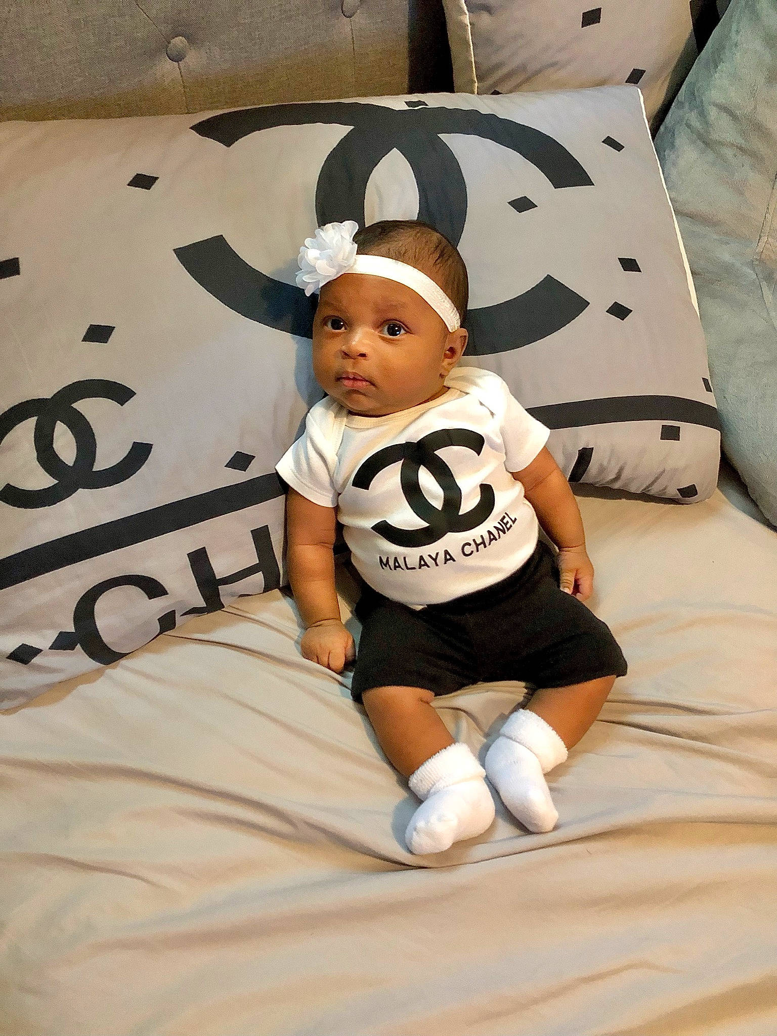 Malaya is registered to the contest to win money with this photo: baby, baby_toddler_clothing, bedding, carmine, child, comfort, flooring, font, fun, happy, jersey, linens, pattern, person, room, shorts, sleeve, sportswear, t_shirt, throw_pillow