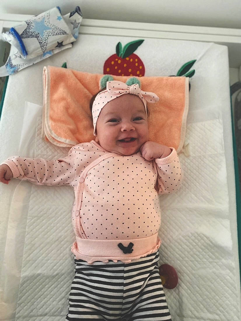 Rea is registered to the contest to win money with this photo: baby, baby_products, baby_safety, baby_sleeping, baby_toddler_clothing, bedding, child, comfort, face, happy, head, headwear, linens, pattern, person, room, sleeve, smile, t_shirt, textile