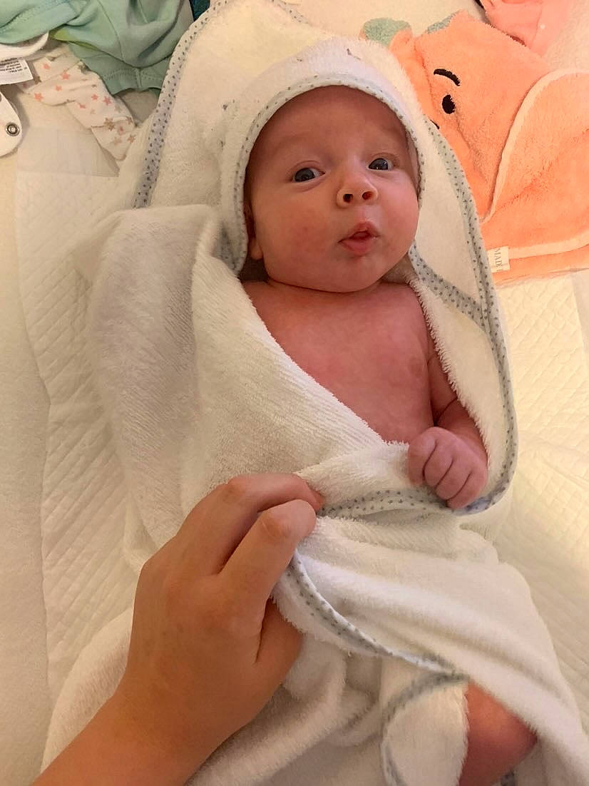 Rea is registered to the contest to win money with this photo: baby, baby_products, baby_safety, baby_sleeping, baby_toddler_clothing, cheek, child, comfort, fashion_accessory, happy, hat, head, headwear, linens, peach, person, room, sitting, skin, smile