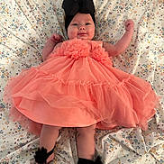 Ivory is registered to the contest to win money with this photo: baby, infant, dress, headband, bow, floral, blanket, smile, cute, happy, child, portrait, lying_down, fabric, soft, pink, black, feet, hands, indoors