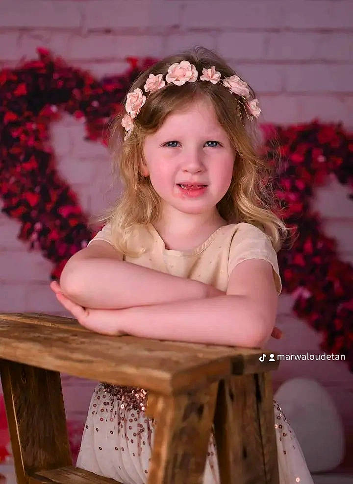 Ema a rejoint le concours — aidez-le/la à gagner de superbes lots ! brown_hair, chair, child, event, eye, face, flash_photography, flower, happy, headband, headpiece, iris, joy, long_hair, person, petal, pink, plant, smile, textile