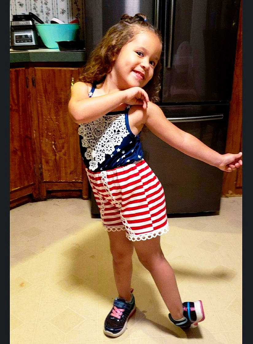 Emry joined the competition — help win amazing prizes! dress, eye, face, fashion_design, flash_photography, gesture, happy, human_leg, joint, joy, knee, leg, neck, one_piece_garment, person, sandal, smile, thigh, thumb, toddler