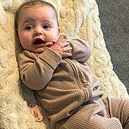 Mina joined the competition — help win amazing prizes! baby, infant, blanket, pacifier, clothing, ribbed_fabric, face, hand, expression, lying_down, floor, carpet, cozy, cute, child, indoor, soft_texture, neutral_colors, portrait, young