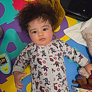 Giulio participe au concours pour gagner de l'argent avec cette photo : baby, child, infant, onesie, superhero, puzzle_mat, toy, plush_toy, colorful, indoor, floor, curly_hair, cute, lying_down, playtime, face, expression, young_child, casual, home