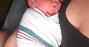 Bennett is registered to the contest to win money with this photo: newborn, baby, wrapped, blanket, sleeping, infant, person, adult, arm, holding, closeup, indoor, resting, peaceful, skin, human, portrait, care, comfort, tenderness