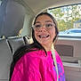 Tabatha Glover is registered to the contest to win money with this photo: child, girl, braces, glasses, pink_shirt, seatbelt, car_interior, car_seat, smile, long_hair, window, daytime, vehicle, casual_clothing, portrait, happy, young_person, automobile, passenger, sunlight