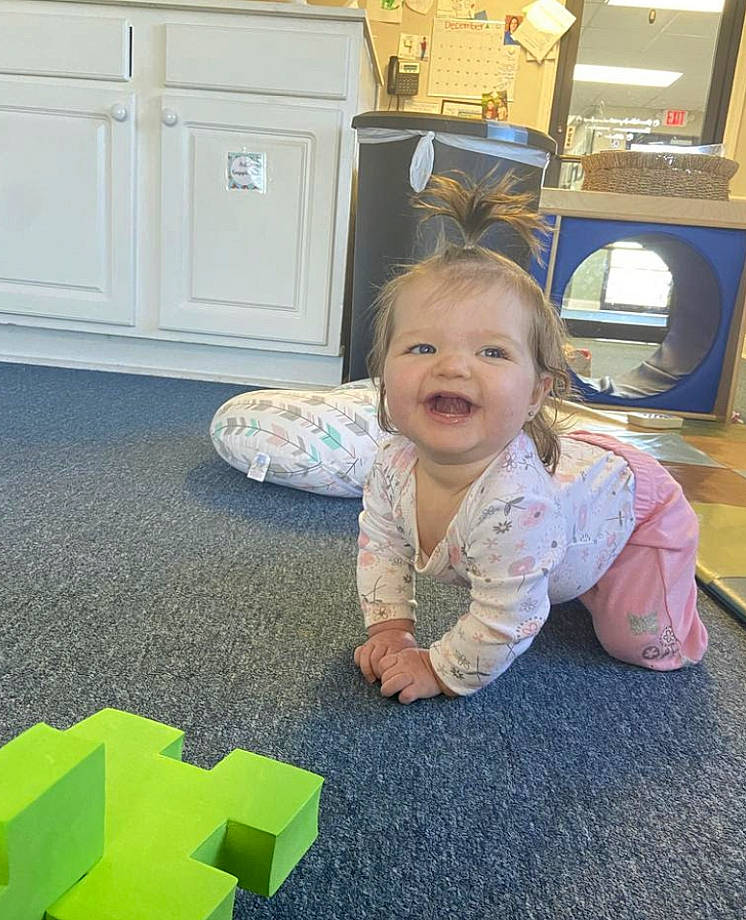 Charlie is registered to the contest to win money with this photo: baby, baby_toddler_clothing, cabinetry, carpet, chest_of_drawers, child, door, drawer, floor, flooring, fun, grass, hardwood, home_appliance, joy, person, play, room, sitting, smile