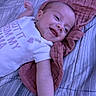 Brooklyn joined the competition — help win amazing prizes! baby, infant, smiling, lying_down, onesie, bedspread, pink_cloth, happy, young_child, face, arm, head, text_on_clothing, cute, indoor, portrait, person, sleepwear, resting, child