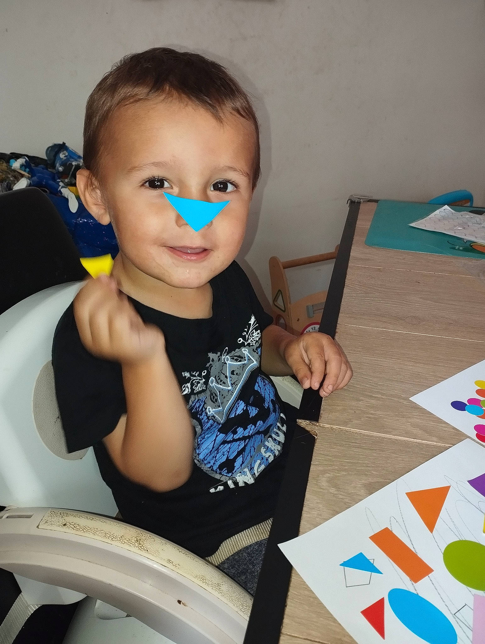 Lucas a rejoint le concours — aidez-le/la à gagner de superbes lots ! arm, automotive_tire, chair, child, electric_blue, eyewear, finger, fun, joy, paint, person, room, sitting, smile, t_shirt, table, tire, toddler, toy, vehicle_door