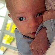 Jai is registered to the contest to win money with this photo: baby, blanket, blue_clothing, child, close_up, cozy, curious, cute, face, hand, indoors, infant, natural_light, newborn, portrait, skin, small_hand, soft, window, wrapping