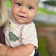 Xavierlee is registered to the contest to win money with this photo: arm, baby, blurred_background, child, closeup, clothing, cute, dinosaur_patch, face, hand, happy, holding, human, infant, nature, outdoor, person, portrait, shirt, smile