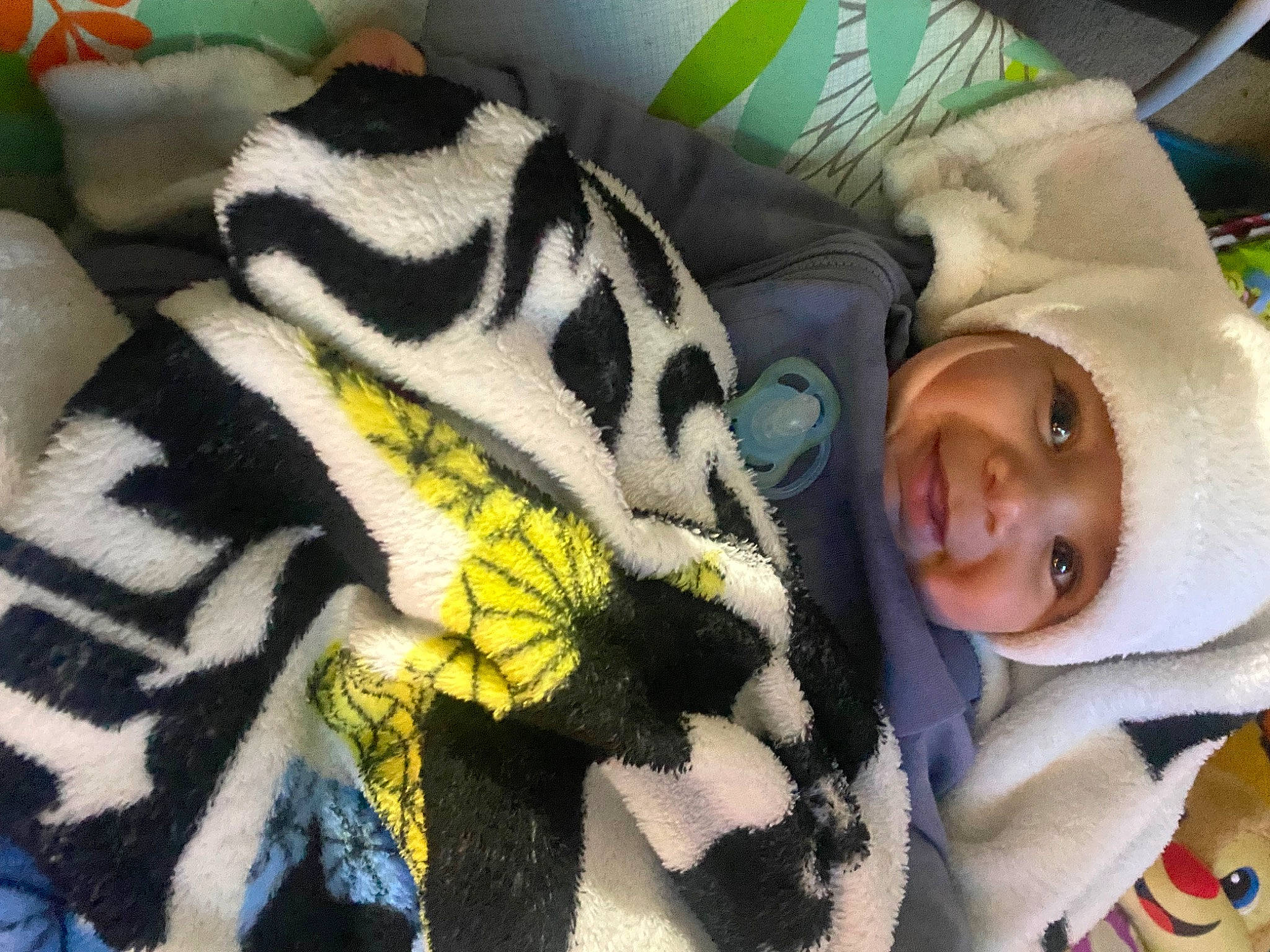 Eli is registered to the contest to win money with this photo: baby, baby_products, baby_toddler_clothing, blanket, child, comfort, fur, happy, headwear, linens, pattern, person, room, sleeve, smile, textile, toddler