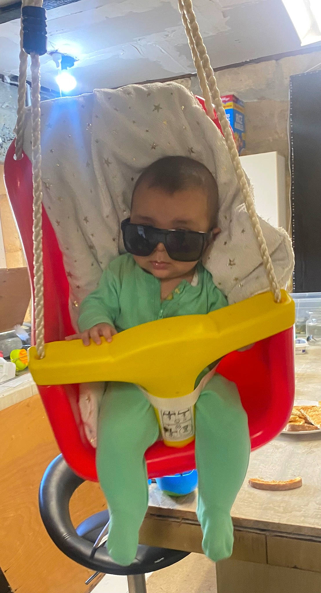 Eli is registered to the contest to win money with this photo: baby_toddler_clothing, child, city, cleanliness, eyewear, fun, goggles, leisure, person, personal_protective_equipment, plastic, play, recreation, riding_toy, sitting, sunglasses, tire, toddler, toy, wheel