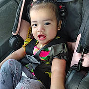 Maxcyan is registered to the contest to win money with this photo: child, toddler, baby, car_seat, car, vehicle, portrait, face, eyes, open_mouth, hair_clips, necklace, harness, seatbelt, colorful_clothing, sitting, indoors, travel, candid,  안전