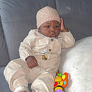 Emerys participe au concours pour gagner de l'argent avec cette photo : baby, infant, child, couch, gray_couch, beige_clothing, knit_hat, pacifier, toy, colorful_toy, sitting, indoor, relaxed, cute, young_child, footwear, plush_couch, portrait, casual, cozy