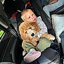 child, toddler, car_seat, dog, curly_hair, fluffy_dog, indoor, car_interior, seat_belt, casual_clothing, footwear, person, cute, pet, travel, comfort, hair_style, holding, friendship, window