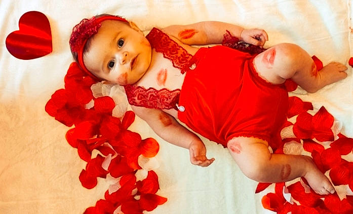 Alyah participe au concours pour gagner de l'argent avec cette photo : baby, baby_toddler_clothing, carmine, child, comfort, event, finger, gesture, hand, happy, holiday, orange, peach, person, petal, plant, product, red, smile, textile