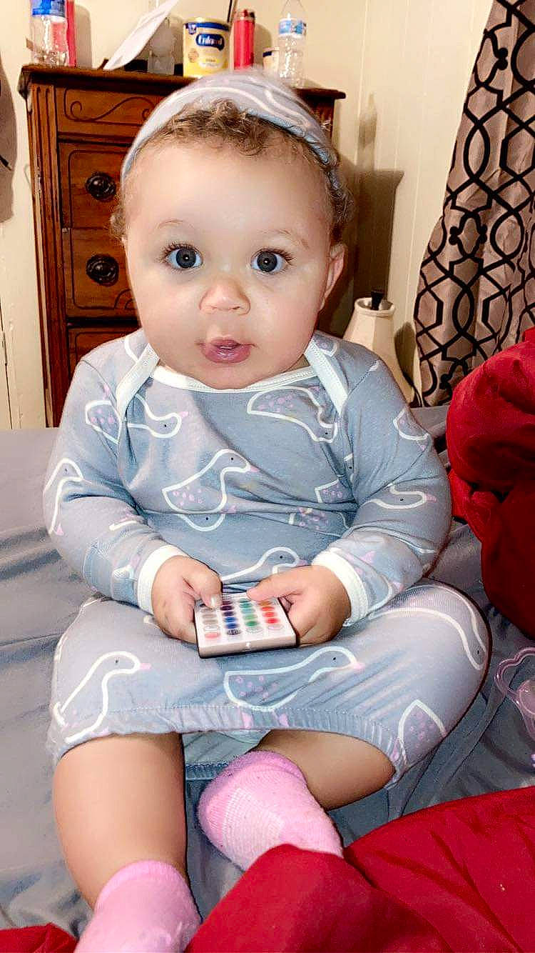 Kahlani is registered to the contest to win money with this photo: arm, baby_toddler_clothing, blue, cabinetry, cheek, child, eye, eyelash, finger, head, iris, knee, leg, mouth, person, pink, skin, sleeve, thigh, toddler