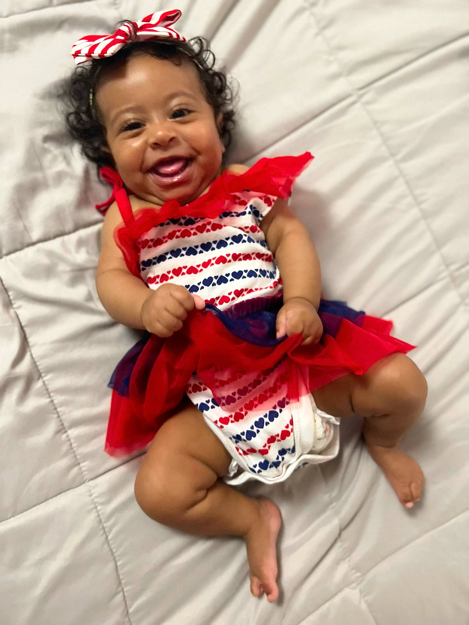 Selina is registered to the contest to win money with this photo: arm, baby_toddler_clothing, comfort, dress, eye, face, facial_expression, finger, gesture, hair, happy, head, human_body, person, pink, skin, sleeve, smile, textile, thigh