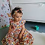 Jaya participe au concours pour gagner de l'argent avec cette photo : toddler, child, dress, headband, playmat, toy, furniture, dresser, curtain, animal_print, indoor, foot, hand, sitting, colorful, patterned_clothing, baby, young_child, cute, portrait