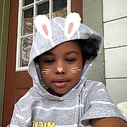 Kharlee is registered to the contest to win money with this photo: child, hoodie, striped_clothing, face, smile, curly_hair, door, window, porch, filter, bunny_ears, whiskers, casual, outdoor, young, person, cute, happy, portrait, relaxed