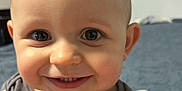 Samson is registered to the contest to win money with this photo: baby, child, smiling, face, eyes, teeth, clothing, shirt, indoor, person, cute, happy, infant, portrait, toddler, closeup, skin, head, toy, background