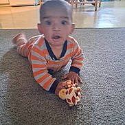 Ovrion joined the competition — help win amazing prizes! baby, child, infant, carpet, giraffe_toy, toy, striped_clothing, orange, gray, indoors, home, floor, sitting, lying_down, curious, eyes_open, portrait, dining_area, furniture, playtime