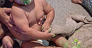 Ovrion is registered to the contest to win money with this photo: baby, child, infant, sitting, smiling, messy, food, avocado, green_food, diaper, barefoot, adult_hand, indoor, carpet, blanket, sock, home, portrait, face, funny