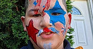 Alyrique joined the competition — help win amazing prizes! child, boy, face_paint, selfie, portrait, outdoor, garden, hedge, front_door, brick_wall, blue_paint, red_paint, star, patriotic, short_hair, smiling, shirt, close_up, person, daylight