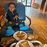 Cruz joined the competition — help win amazing prizes! boots, boy, cafe, chair, child, coat, cookie, door, drink_bottle, eating, floor, highchair, interior, plate, rain_boots, sandwich, smiling, table, toddler, window