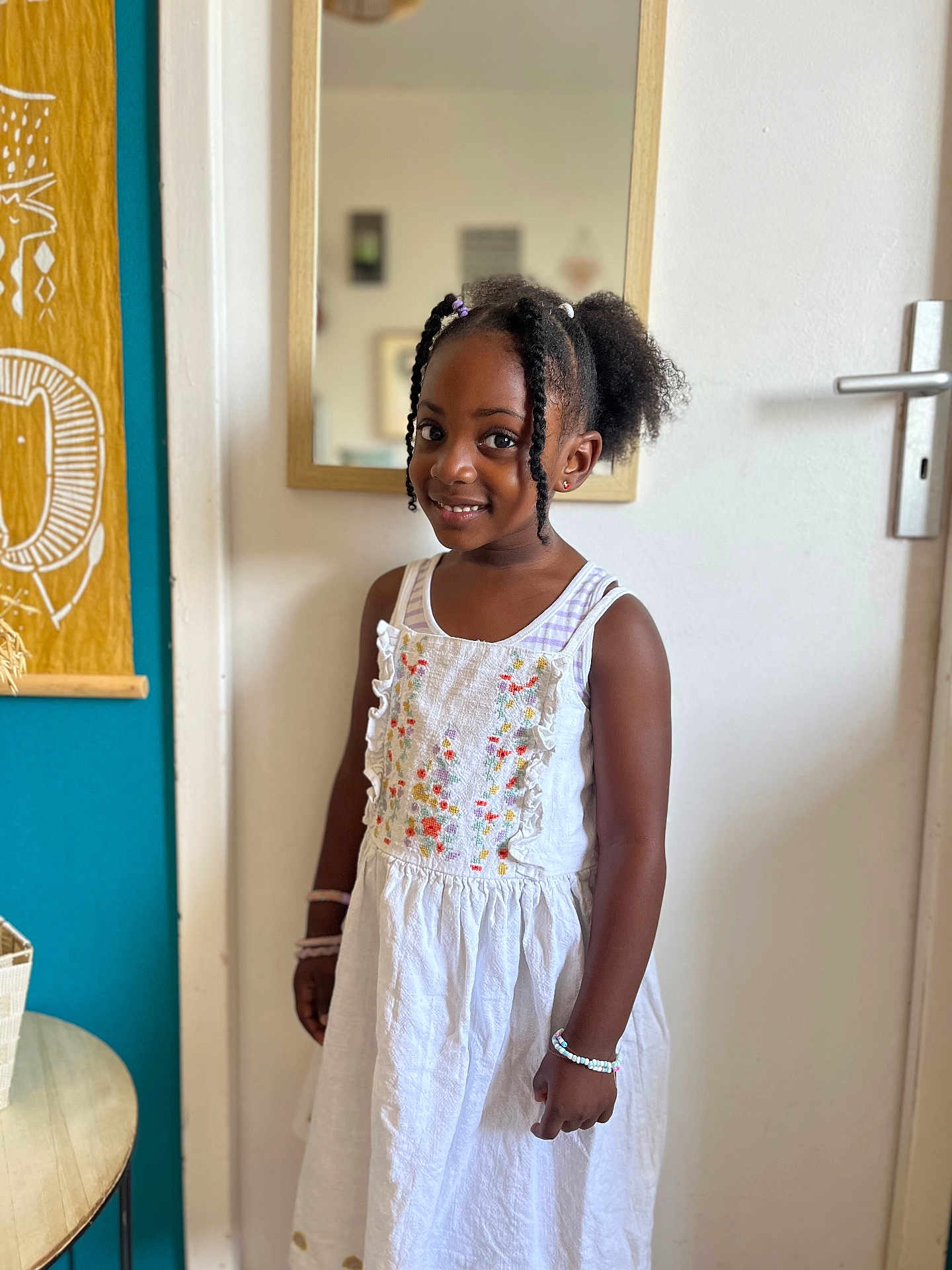 Talia participe au concours pour gagner de l'argent avec cette photo : child, girl, smile, dress, white_dress, bracelet, indoor, mirror, door, hairstyle, curly_hair, pigtails, tapestry, table, basket, wall, portrait, happy, standing, room