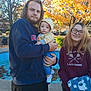 baby, child, man, woman, family, hoodie, glasses, blanket, fall, autumn, outdoor, trees, leaves, park, smile, casual_clothing, portrait, daylight, holding, people