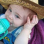 baby, child, hat, straw_hat, bottle, drink, purple_blanket, blue_clothing, cute, face, hand, infant, sitting, portrait, indoors, closeup, expression, young, person, baby_bottle