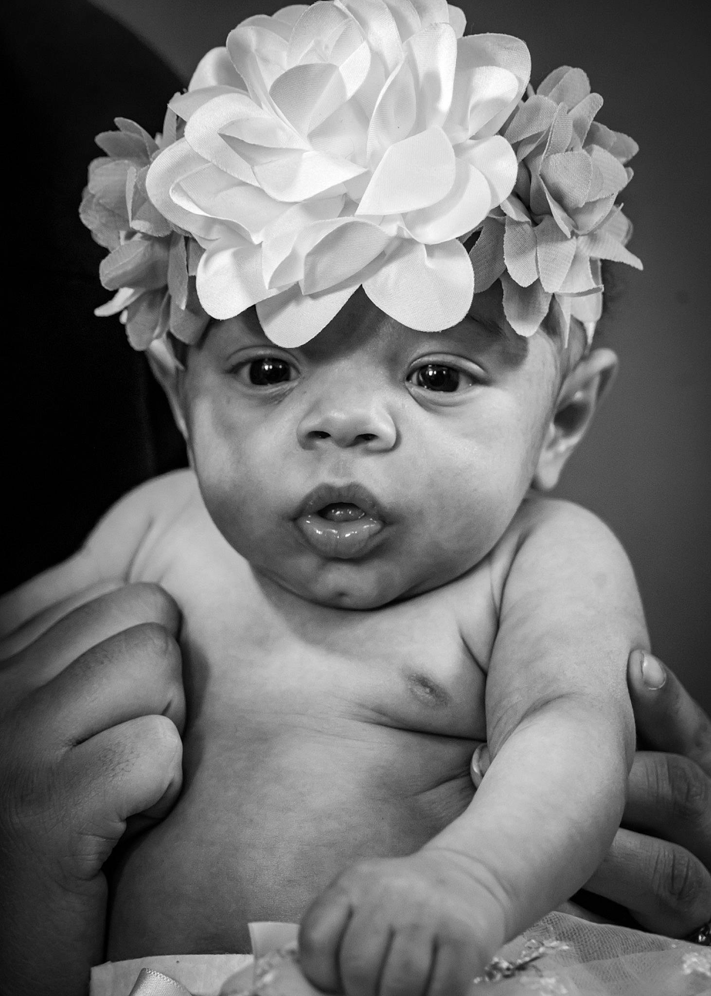Kaylani joined the competition — help win amazing prizes! baby, black_and_white, cap, eye, finger, flower, gesture, hand, happy, hat, headgear, headpiece, human_body, monochrome, person, petal, photograph, plant, style, toddler