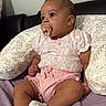 Nora is registered to the contest to win money with this photo: baby, bed, child, clothing, comfortable, cute, face, floral_top, head, indoors, infant, pacifier, person, pillow, pink_shorts, relaxed, sitting, skin, socks, young_child
