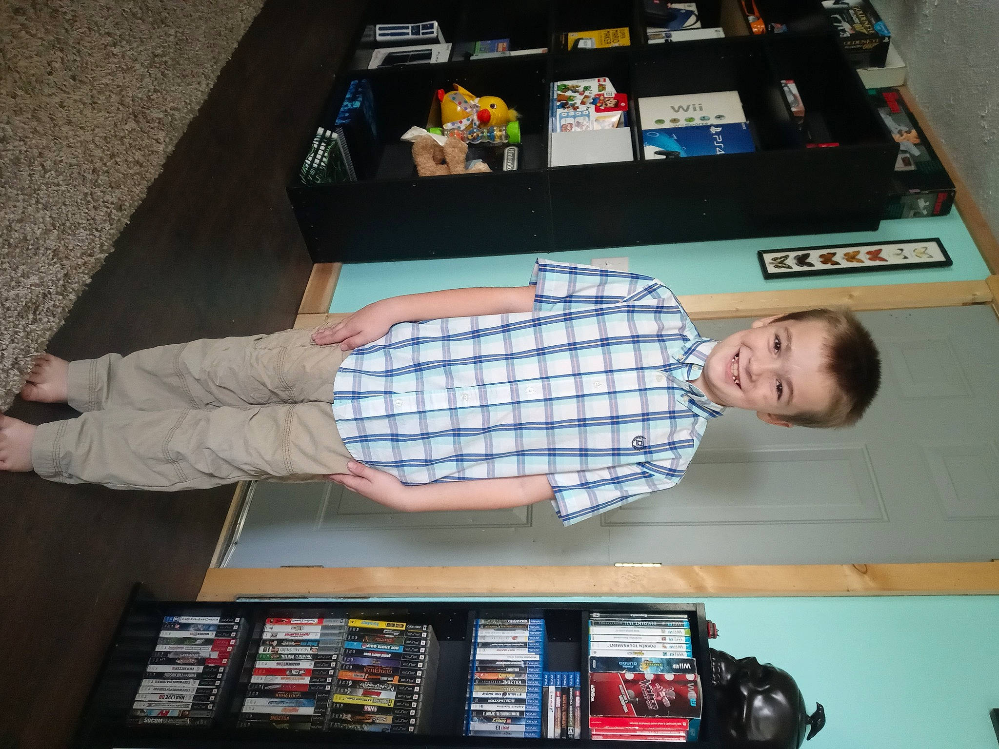 Ryder is registered to the contest to win money with this photo: automotive_exterior, box, child, display_device, electronic_device, electronics, flooring, fun, gadget, games, joy, machine, pattern, person, play, recreation, room, t_shirt, technology, toy