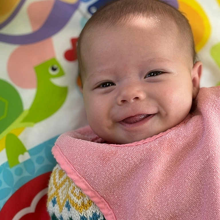 Makanna is registered to the contest to win money with this photo: applique, baby, bib, blanket, face, happy, head, laughing, newborn, pattern, person, photography, portrait, quilt, smile, towel
