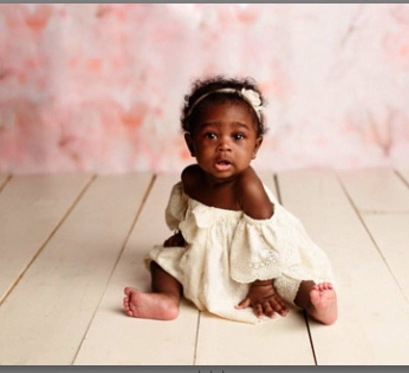 Bailee is registered to the contest to win money with this photo: baby, baby_toddler_clothing, cheek, child, dress, face, floor, flooring, foot, fun, happy, hardwood, head, person, pink, sitting, skin, sleeve, smile, toddler