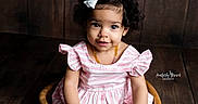 Karma joined the competition — help win amazing prizes! amber_necklace, big_eyes, child, curly_hair, cute, girl, hands, photography, pink_striped_dress, portrait, prop, sitting, smile, studio_portrait, toddler, watermark, white_bow, wood_panel_wall, wooden_bowl, wooden_floor