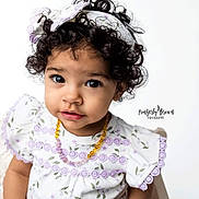 Karma is registered to the contest to win money with this photo: child, toddler, baby, curly_hair, headband, floral_dress, purple_lace, amber_necklace, big_eyes, eyelashes, studio_portrait, white_background, wooden_chair, close_up, expressive_face, adorable, sitting, innocence, soft_lighting, photographer_watermark