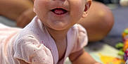 Sophia is registered to the contest to win money with this photo: baby, child, infant, smiling, playmat, colorful, face, hands, tongue, clothing, person, background, blurred, happy, cute, indoors, skin, eyes, young, pale_pink