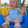 baby, child, swing, outdoor, smiling, happy, blue_dress, footwear, grass, tree, toy, playground, person, cute, summer, nature, greenery, sunlight, toddler, fun