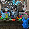 bulldog, dog, bunny_ears, bandana, easter_eggs, basket, plaid, toy, decoration, carpet, wood_floor, holiday, festive, indoors, cute, pet, colorful, spring, playful, easter