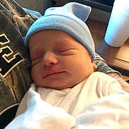 Lucas joined the competition — help win amazing prizes! newborn, baby, sleeping, hat, blue_hat, white_clothing, infant, person, cradled, indoor, table, cup, resting, peaceful, closeup, headwear, soft_light, portrait, human, care