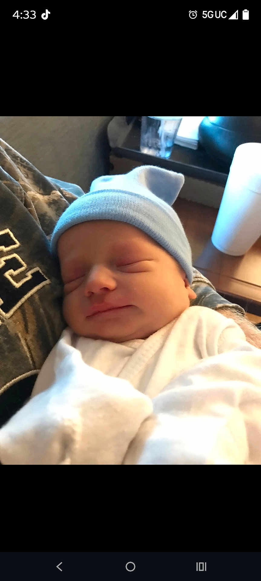 Lucas joined the competition — help win amazing prizes! newborn, baby, sleeping, hat, blue_hat, white_clothing, infant, person, cradled, indoor, table, cup, resting, peaceful, closeup, headwear, soft_light, portrait, human, care