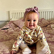 Georgia joined the competition — help win amazing prizes! baby, bed, bedspread, bow, butterfly, child, childhood, clothing, cute, happy, headband, indoor, infant, pattern, person, portrait, sitting, smiling, toddler, young